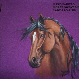 May include: Purple hand-painted horse sweat shirt with the text "HAND-PAINTED HORSE SWEAT SHIRT LADY'S LG-PLUM" and the artist's signature "WorFo DEEMS".