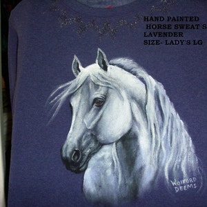 May include: Hand-painted lavender sweatshirt with a white horse design. The shirt says "HAND PAINTED HORSE SWEAT SHIRT LAVENDER SIZE-LADY'S LG" and is signed "WOIFORD DEEMS".