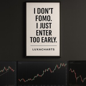 Puede incluir: Un póster enmarcado con el texto "I DON'T FOMO. I JUST ENTER TOO EARLY." y el logotipo de Luxacharts. Debajo, tres monitores de ordenador muestran gráficos bursátiles. Un teclado, un ratón y una taza negra están sobre un escritorio de madera.