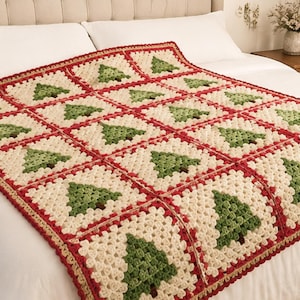 May include: A handmade crochet blanket featuring a repeating pattern of square motifs, each displaying a green Christmas tree on a cream-coloured background. The squares are joined with a red border, and the entire blanket is edged in red yarn.