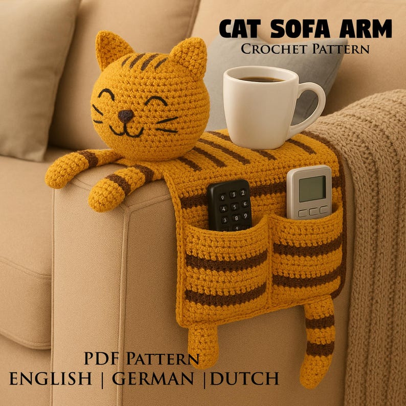 May include: A mustard yellow and brown striped crochet cat sofa arm organizer featuring a cat head, two front pockets, and a tail. The organizer holds a white mug, a black remote, and a gray remote. Text reads: CAT SOFA ARM CROCHET PATTERN PDF PATTERN ENGLISH | GERMAN | DUTCH.