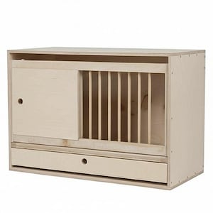 Peut inclure: Un nichoir en bois de couleur claire avec une porte coulissante, des barreaux verticaux et un tiroir. Le nichoir est rectangulaire et présente un design simple et fonctionnel. Le bois a un aspect naturel et non fini.