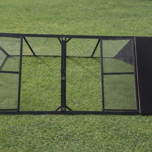May include: A black metal pet enclosure with wire mesh panels and a solid black side panel. The enclosure is rectangular and sits on a green grassy surface. The design includes hinged doors for access.