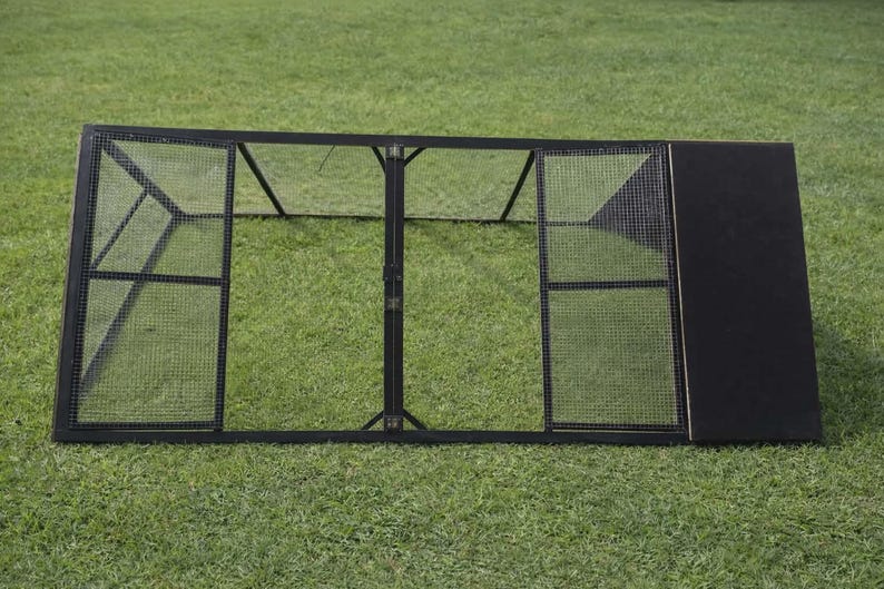 May include: A black metal pet enclosure with wire mesh panels and a solid black side panel. The enclosure is rectangular and sits on a green grassy surface. The design includes hinged doors for access.