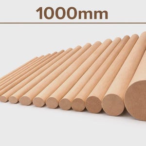May include: A collection of wooden dowels of varying diameters, arranged diagonally. The text "1000mm" is displayed above the dowels, indicating the length. The dowels are made of light-colored wood and are set against a neutral background.
