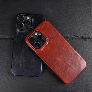 Pode incluir: Duas capas para smartphone com acabamento texturizado, uma em azul-marinho profundo e a outra em um rico tom castanho-avermelhado. Cada capa possui um recorte preciso para um sistema de câmera tripla, com um design elegante que cobre o verso.