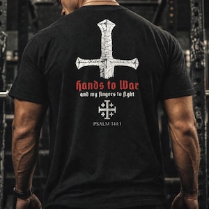 May include: A black t-shirt featuring a white graphic of an inverted sword, the red and white text "hands to War and my fingers to fight", a white Jerusalem cross symbol, and the white text "PSALM 144:1" printed on the back of the garment.