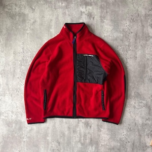 May include: A red fleece jacket with a black pocket and trim. The jacket has a full-length zipper and a high collar. The brand name "RL POLO JEANS CO." is visible on the pocket. The jacket also has the text "RL-67" on the left sleeve.