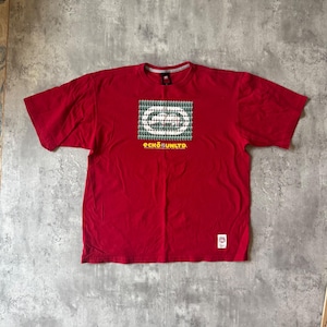 May include: A red short-sleeved t-shirt with a graphic design on the front. The graphic is a series of white and green ovals within a rectangle. The text "ECKO UNLTD." is below the graphic in yellow.
