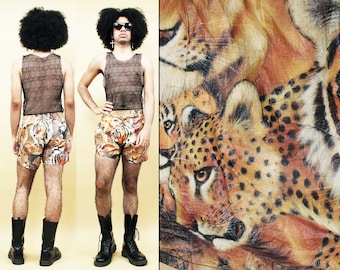 May include: A person wearing a black mesh tank top and animal print swim trunks. The swim trunks feature a cheetah print with brown, orange, and black colors.