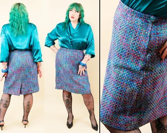 May include: A knee-length skirt with a woven pattern in shades of blue, purple, and red. The skirt has a button closure and a tailored fit. The model is wearing a teal blouse.