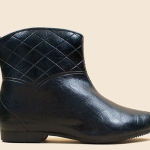 May include: Black quilted ankle boots with a rounded toe and a low heel.