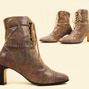 May include: A pair of brown leather ankle boots with lace-up fronts and block heels. The boots have a textured, snakeskin-like pattern.