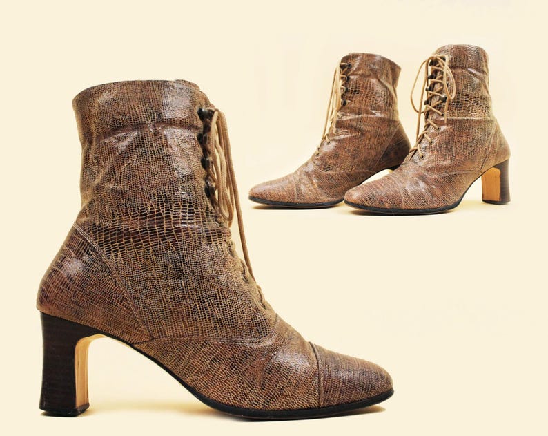 May include: A pair of brown leather ankle boots with lace-up fronts and block heels. The boots have a textured, snakeskin-like pattern.