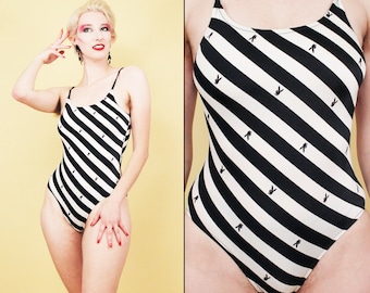 May include: Black and white striped swimsuit with a diagonal pattern and a small bunny logo repeated throughout.