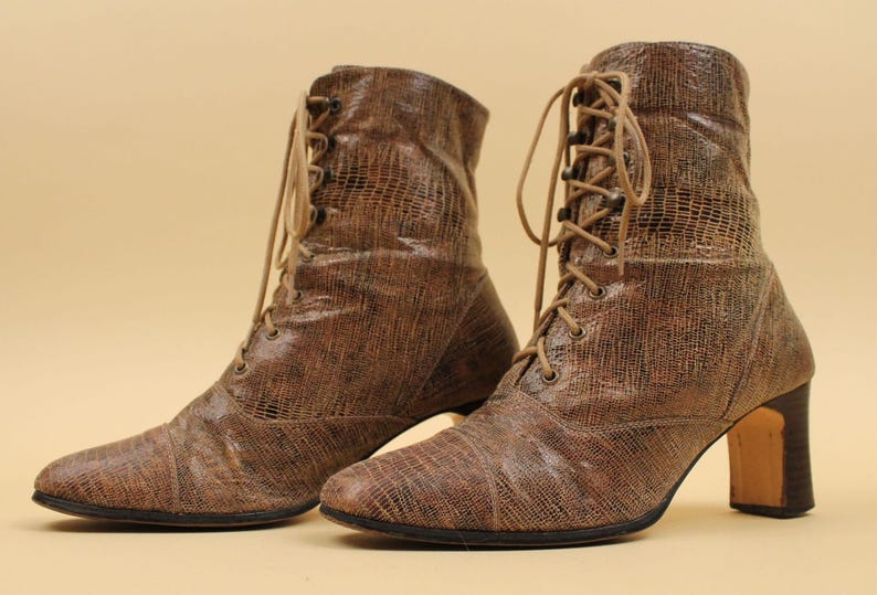 May include: A pair of brown leather lace-up boots with a textured finish and a block heel.