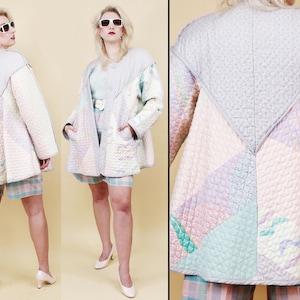 May include: A quilted jacket in pastel colors, featuring a geometric design with shades of pink, blue, and lavender. The jacket has a unique, oversized silhouette with a high collar and large pockets. The outfit includes matching shorts.