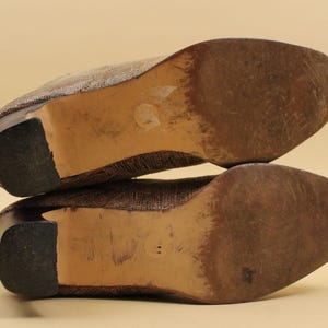 May include: A pair of brown woven heeled shoes with a brown leather sole. The shoes are stacked on top of each other.
