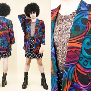 May include: A vintage blazer with a vibrant paisley pattern in shades of red, orange, blue, and teal on a black background. The blazer is paired with a polka dot skirt and black boots, creating a bold, retro look.