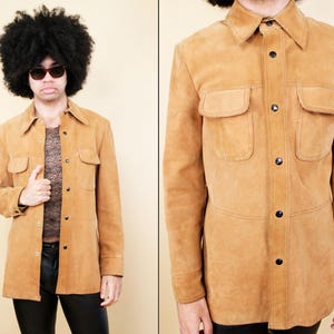 Może przedstawiać: Brązowa kurtka zamszowa w stylu koszuli z zapięciem na guziki i dwoma kieszeniami z klapkami. Kurtka ma długie rękawy i luźny krój.