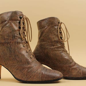 May include: A pair of brown leather ankle boots with lace-up fronts and block heels.