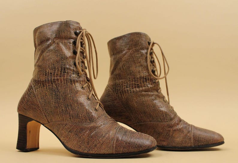 May include: A pair of brown leather ankle boots with lace-up fronts and block heels.