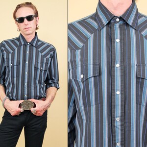 May include: A black and blue striped long-sleeve shirt with a western style collar and two chest pockets.
