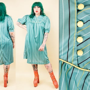 May include: A teal-colored, vertically striped dress with short sleeves and a knee-length hemline. The dress features a button-up front with large yellow buttons and a yellow trim. The fabric has black and white stripes. The dress is vintage-inspired.