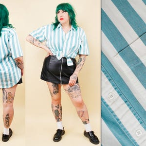 May include: A short-sleeved, button-down shirt with vertical stripes in white and teal. The shirt is tied at the waist. The image also shows a black leather mini-skirt and black shoes.