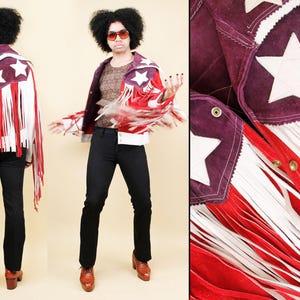 Puede incluir: Chaqueta de ante con diseño patriótico. La chaqueta presenta un canesú burdeos con estrellas blancas, flecos rojos y blancos y un estampado de rayas rojas y blancas. La chaqueta se usa con pantalones negros y botas marrones.