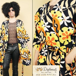 May include: A black and yellow floral print robe with a tie belt. The robe has a large floral pattern with orange, yellow, and white flowers. The label reads "Diplomat All Cotton One Size Fits All".