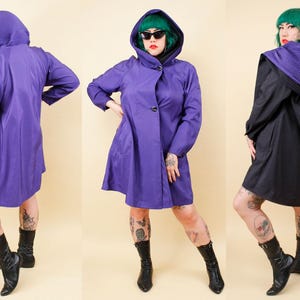 May include: A purple hooded coat with a button closure and long sleeves. The coat is shown from multiple angles, highlighting its design and fit. The hood has a pleated texture. The model is wearing black boots.