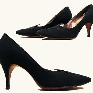 May include: A pair of black high-heeled shoes with a delicate lace detail on the toe.