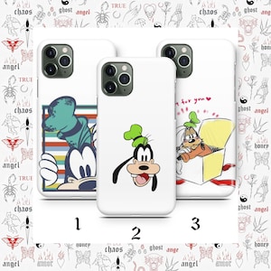 May include: Three white phone cases with cartoon character designs. One case features Goofy with a striped background, another shows Goofy's face, and the third depicts Goofy in a box. The cases have black camera surrounds.