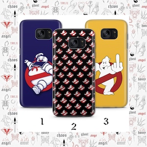 May include: Three phone cases with Ghostbusters-themed designs. One case is navy blue with the Stay Puft Marshmallow Man, another is black with a repeating Ghostbusters logo, and the third is yellow with a Ghostbusters ghost giving the middle finger.