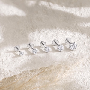 May include: Five silver-toned labret studs arranged in a row, each featuring a round, clear, faceted stone set in a circular base. The flat back of each stud is clearly engraved with the text S925, indicating the metal composition of the jewelry.