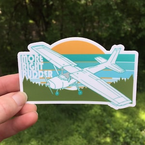 May include: A white airplane sticker with a green and blue sunset background. The sticker says "More Right Rudder" in a retro font.