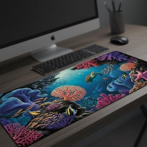 May include: A rectangular desk mat featuring a vibrant underwater scene. The design includes colorful coral, fish, a sea turtle, and starfish. The color palette includes blues, purples, oranges, and pinks. The mat is placed on a wooden desk with a computer and keyboard.