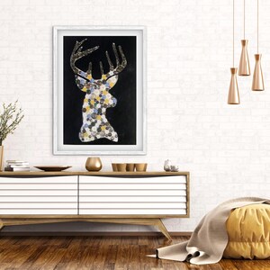 以下が含まれることがあります： 黒い背景に鹿の頭のシルエットを描いた額入りのアートワーク。 鹿の形は、カラフルな円形のモザイクで満たされています。 枝角は質感のある外観です。 アートワークは木製のキャビネットの上に展示されています。