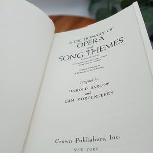 May include: Open book titled "A Dictionary of Opera and Song Themes" by Harold Barlow and Sam Morgenstern. The book is published by Crown Publishers, Inc. in New York. The pages are off-white with black text.