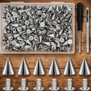 Könnte beinhalten: Ein durchsichtiger Kunststoffbehälter gefüllt mit zahlreichen silberfarbenen, kegelförmigen Metallnieten und passenden Schraubverschlüssen. Daneben liegen ein Schraubendreher mit schwarzem Griff und ein silbernes Lochwerkzeug.