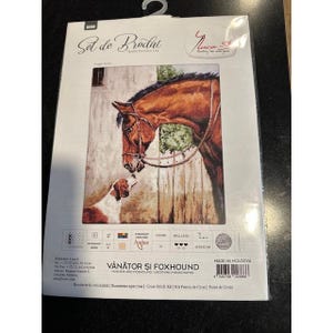Pode incluir: Um kit de ponto cruz com uma imagem de um cavalo castanho e um cão, com o texto "VÂNĂTOR ȘI FOXHOUND". O kit inclui fio Anchor e é feito na Moldávia. A imagem mostra um cavalo com uma rédea e um cão.