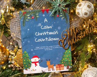 May include: A blue Christmas countdown card with a snowman and reindeer illustration, and the text "A Calm Christmas Countdown." The card is decorated with Christmas tree ornaments and a gold "Merry Christmas" sign.