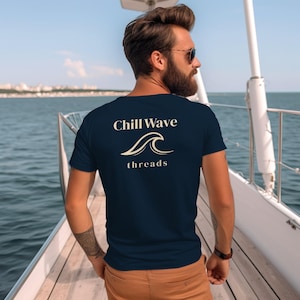 May include: Navy blue t-shirt with the text "Chill Wave threads" and a wave graphic. The shirt is worn by a person on a boat, with the ocean and sky in the background.