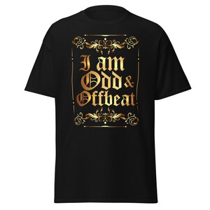 May include: Black t-shirt with a gold-colored design. The design features the text "I am Odd & Offbeat" in an ornate, gothic-style font, framed by decorative flourishes. The shirt is a classic crew neck style.