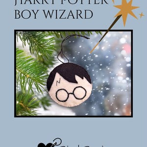 May include: A felt ornament featuring a boy wizard design with black hair, glasses, and a lightning bolt scar. The ornament is hanging from a black string. The text "HARRY POTTER BOY WIZARD" is at the top. The Bird Brain Feltworks logo is at the bottom.
