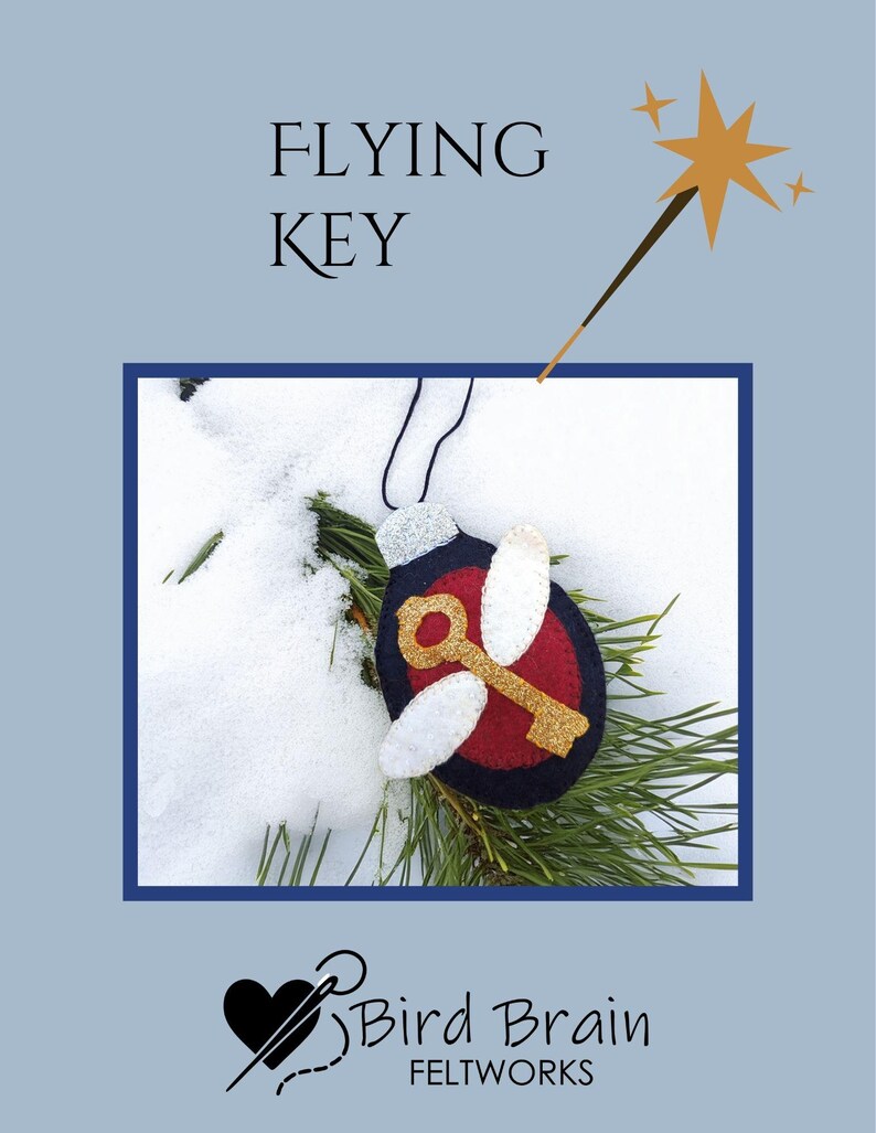 May include: A felt ornament featuring a key with wings, set against a snowy backdrop. The ornament has a red center, gold key, and white wings, with the text "FLYING KEY" above. A gold star wand is also present.