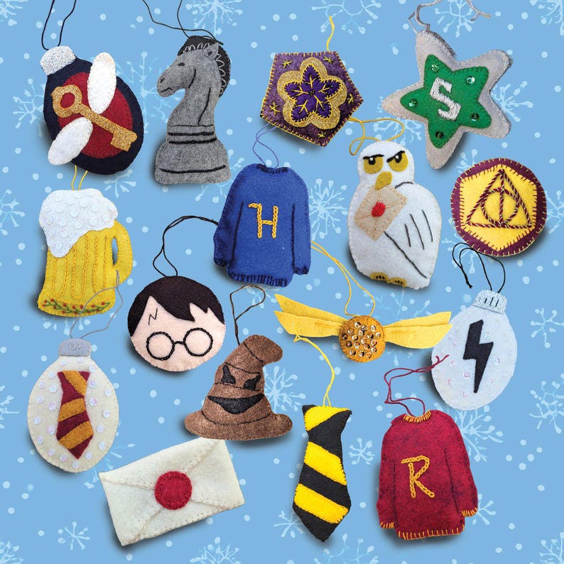 May include: A collection of handmade felt ornaments in various shapes and colors. The ornaments include a chess piece, a star, a sweater, a beer mug, a lightning bolt, a golden snitch, and other themed designs. The background is a light blue with white snowflake patterns.