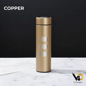 K&ouml;nnte beinhalten: Eine kupferfarbene isolierte Wasserflasche mit schwarzem Deckel. Der Text "YOUR LOGO HERE" ist in Silber auf der Vorderseite aufgedruckt. Das Wort "COPPER" steht in Wei&szlig; oben links. Die Flasche steht auf einer wei&szlig;en Marmoroberfl&auml;che.