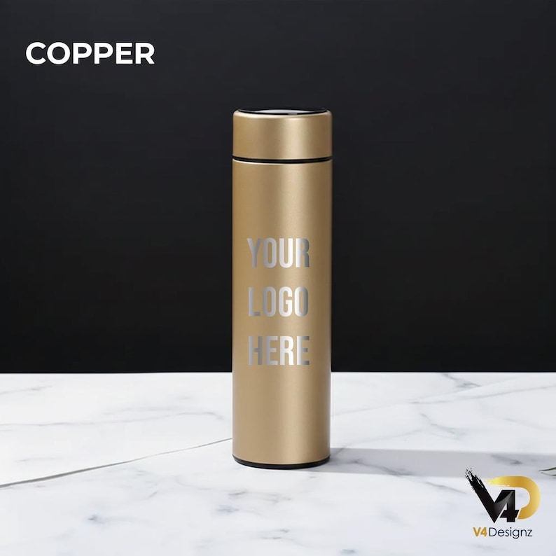 K&ouml;nnte beinhalten: Eine kupferfarbene isolierte Wasserflasche mit schwarzem Deckel. Der Text "YOUR LOGO HERE" ist in Silber auf der Vorderseite aufgedruckt. Das Wort "COPPER" steht in Wei&szlig; oben links. Die Flasche steht auf einer wei&szlig;en Marmoroberfl&auml;che.